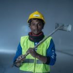 Portrait of a construction worker indoors with safety gear, showcasing a confident pose.