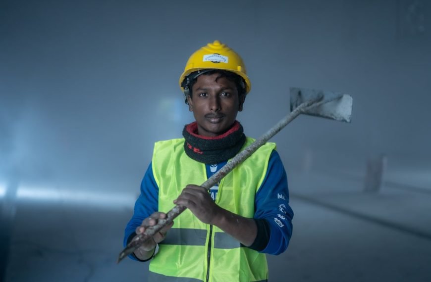 Portrait of a construction worker indoors with safety gear, showcasing a confident pose.