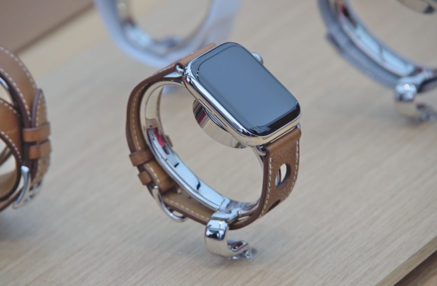 Close-up of a sleek smartwatch with a leather strap displayed on a wooden surface.