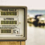 Blurred background view with focus on fuel pump display showing price and liters.