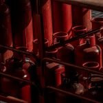 A collection of red gas cylinders stored in an industrial setting, Dubai.