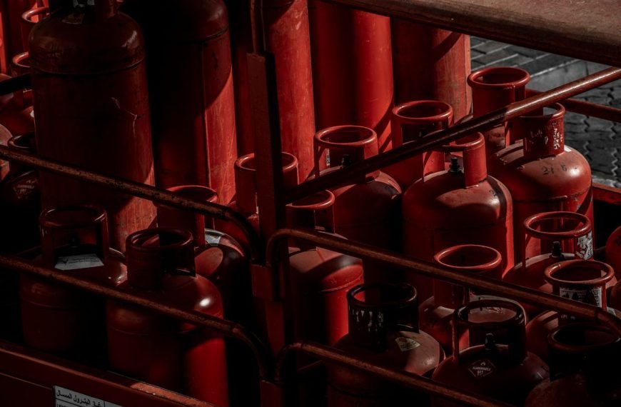 A collection of red gas cylinders stored in an industrial setting, Dubai.