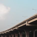 A concrete viaduct stretches beneath a clear blue sky. Captured in Dhaka, Bangladesh.