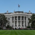A picturesque view of the White House with the American flag in daylight.