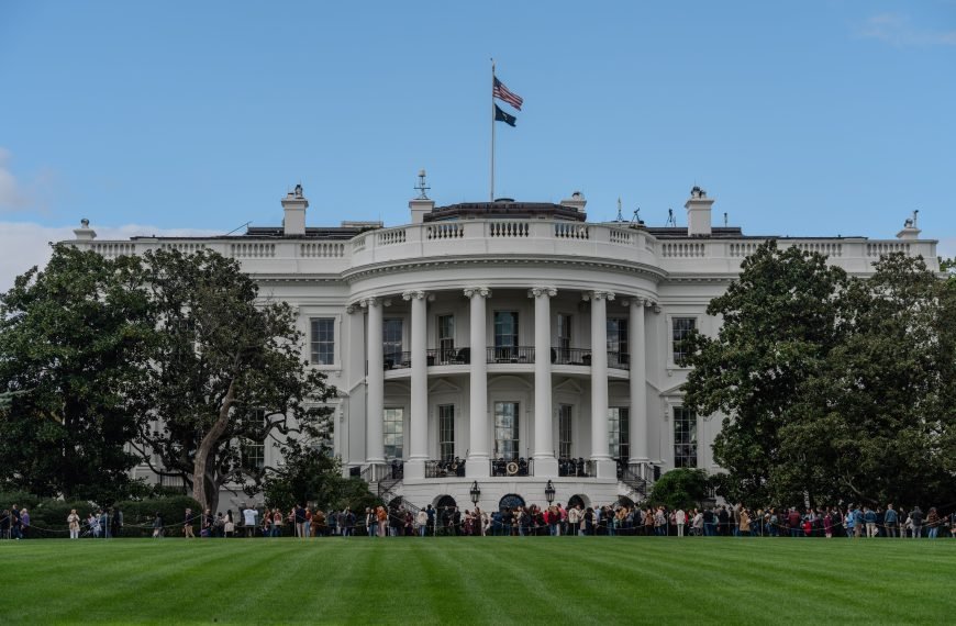A picturesque view of the White House with the American flag in daylight.
