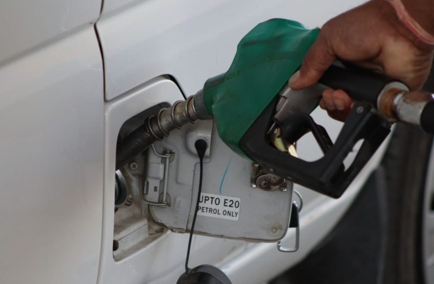 Close-up of a hand refueling a vehicle. E20 petrol pump nozzle in use.
