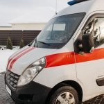 Close-up of a red and white ambulance vehicle parked outdoors during the day.